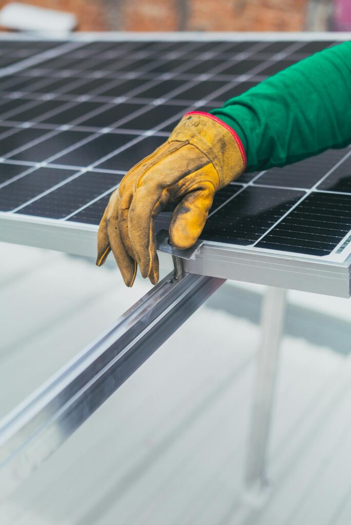 Gloved arm resting on top of a solar panel